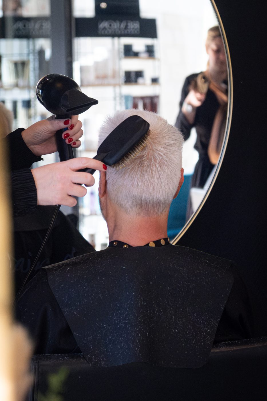 Coiffeur en plein brushing dans son salon